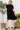 Rear view of chic button dress on model, Black