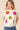 Woman wearing a white sweater with colorful flower patterns on a beige background