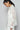 Side view of white shirt with relaxed fit and long crochet sleeves