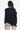 Back view highlighting the elegant and trendy design of the cold shoulder knit top, Black
