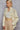 Side view of beige shirt with relaxed silhouette and long cuffed sleeve