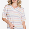 Portrait of a woman in a pastel striped v-neck t-shirt, paired with light denim, perfect for a relaxed summer outfit.