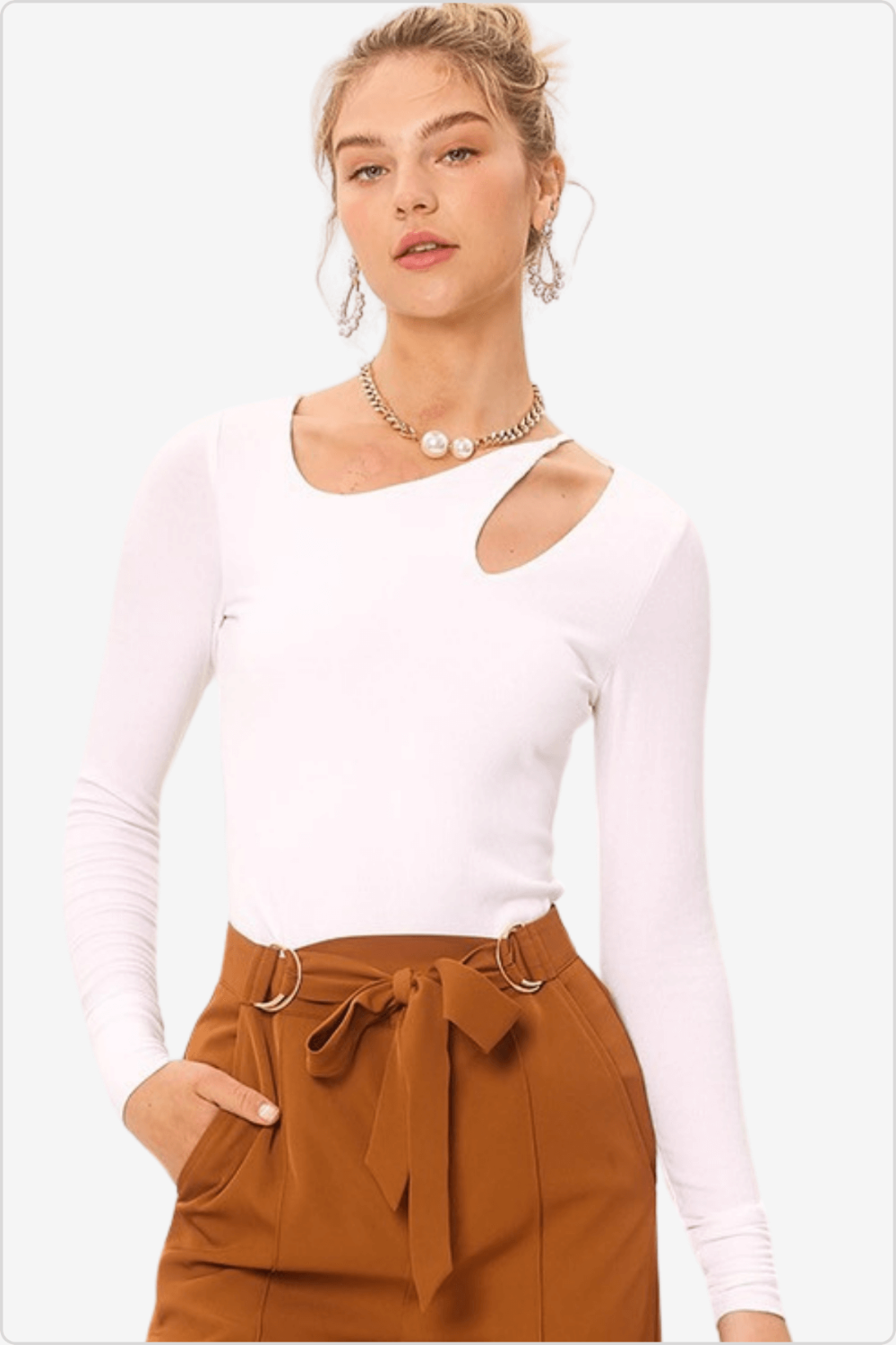 Fashion-forward model in a white knit top with a front cut-out, paired with a pearl choker and high-waist trousers.