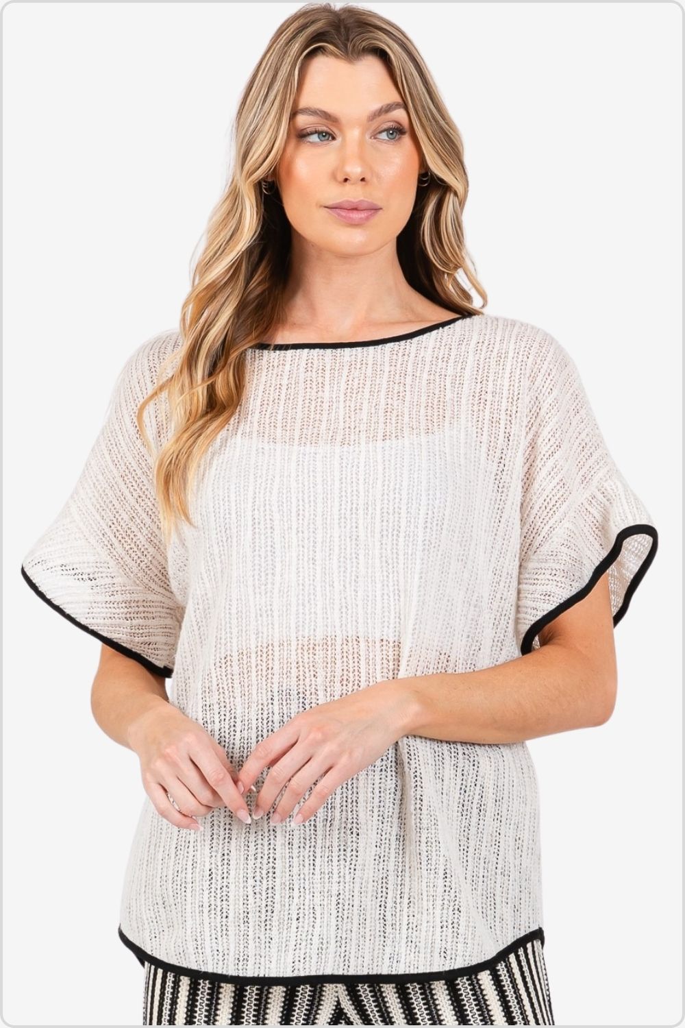 Stylish knit cover-up with black contrast trim and short sleeves.