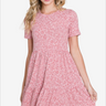 Joyful woman in a delicate pink floral print skater dress with a round neck and short sleeves, epitomizing soft summer elegance.