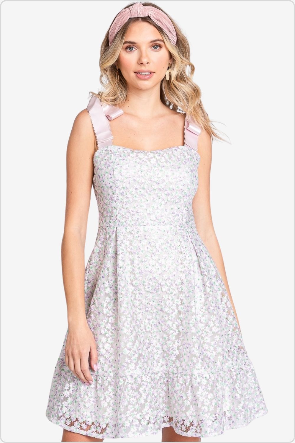 Woman in sleeveless mesh dress with delicate floral embroidery and pink straps