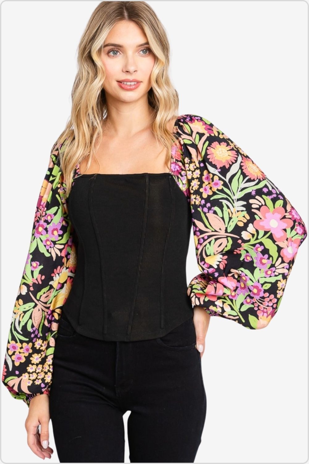 Woman in black corset top with vibrant floral balloon sleeves