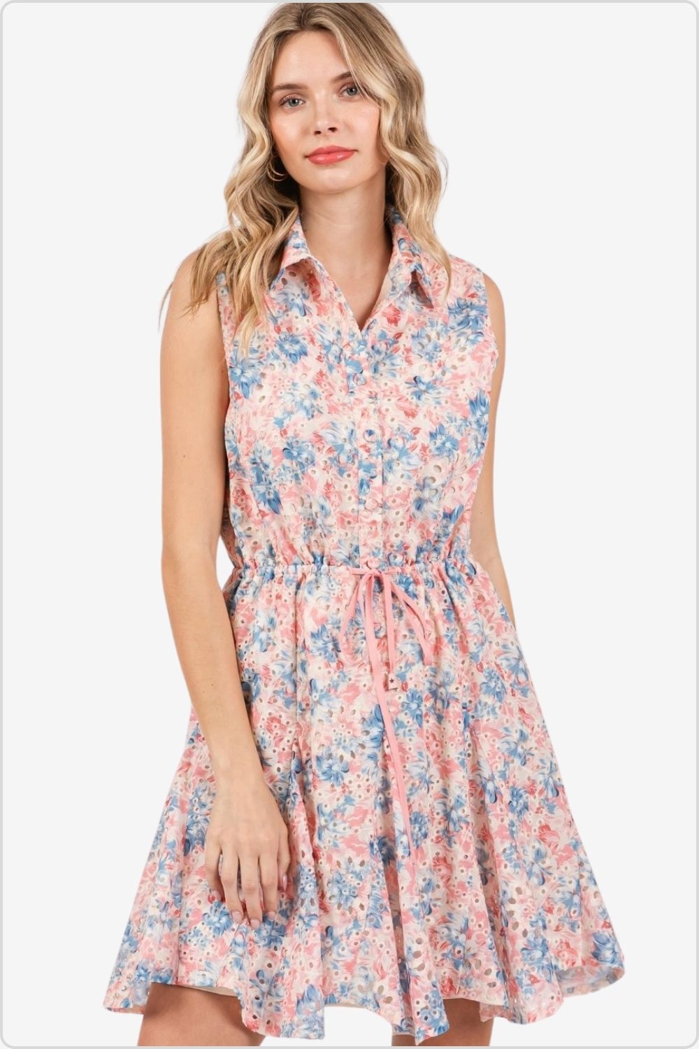 Woman in pink and blue floral sleeveless mini dress.