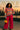 Bright sweater styled with red wide-leg pants, black shoes, and yellow mini handbag