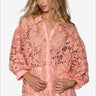 Woman in peach lace shirt with button-up front and collared neck