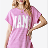 Smiling woman modeling a pink knitted t-shirt with MAMA print.