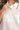Close-up of ribbed fabric and button collar on pink striped knit sweater.