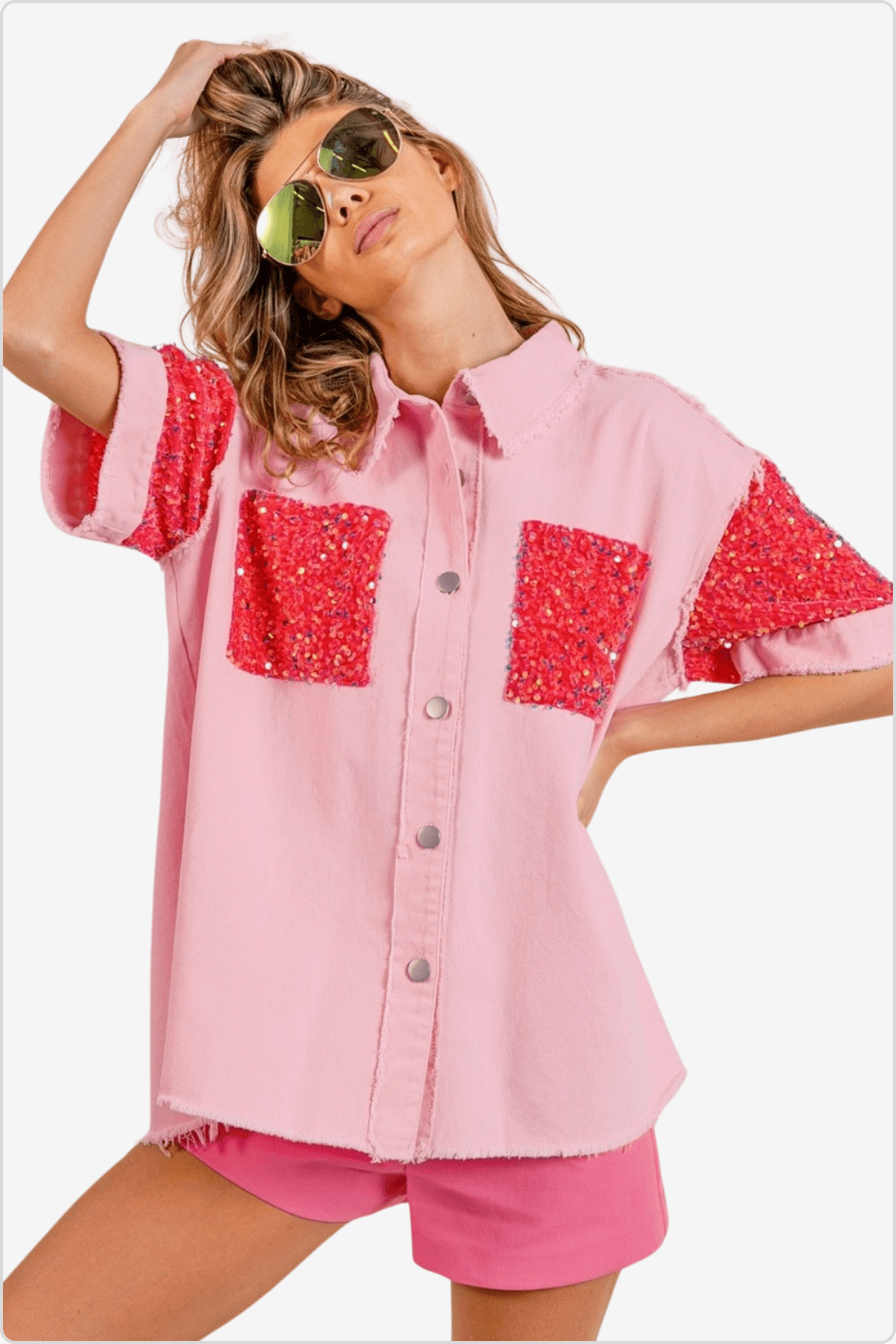 Trendy model in pink shirt with sequin pockets and matching shorts, wearing sunglasses.