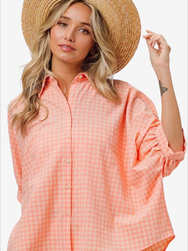 Stylish woman in plaid button-up shirt with straw hat