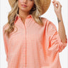 Stylish woman in plaid button-up shirt with straw hat