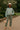 Sea foam sweater paired with olive green utility pants, beige boots, and a felt hat