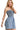 Side view of smocked denim romper highlighting feminine straps and chic design.