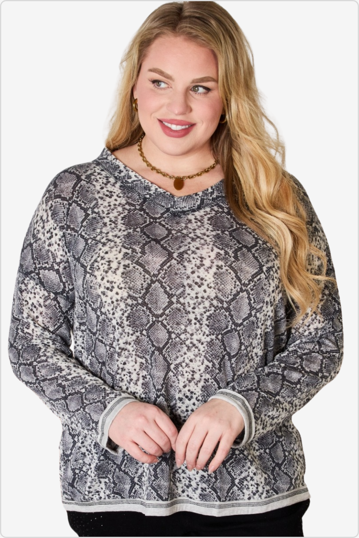 Woman with golden locks wearing a chic snakeskin print sweater, adding an edgy yet cozy touch to her outfit.