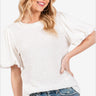 Happy woman in a textured puff-sleeve top and jeans