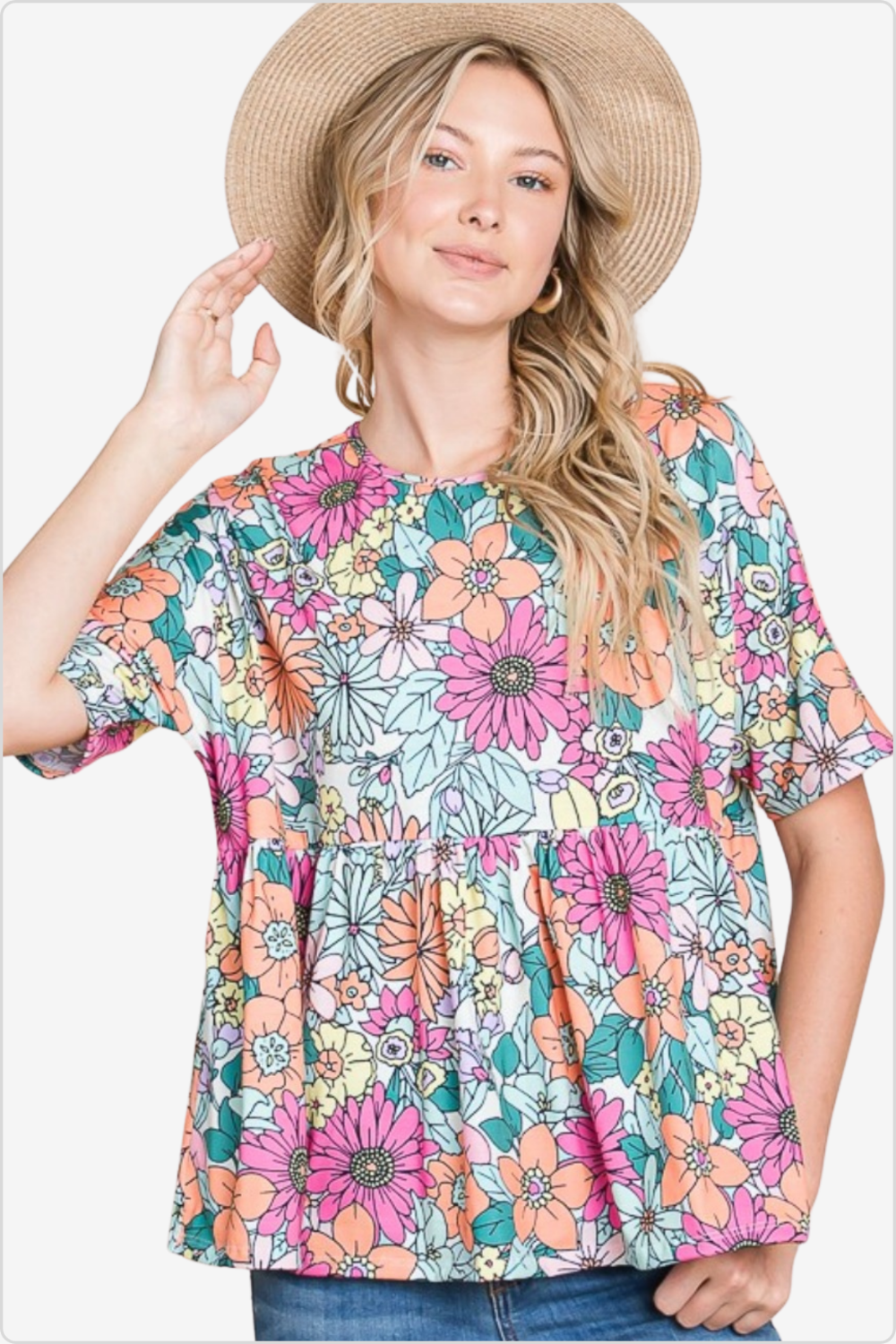 Woman with a straw hat wearing a colorful floral print blouse with short sleeves, styled with classic denim jeans.