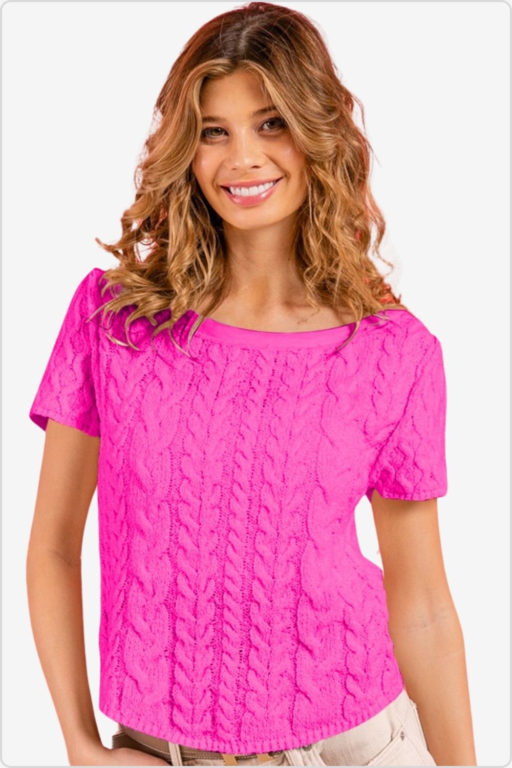 Cheerful woman modeling a vibrant pink short-sleeved cable knit top