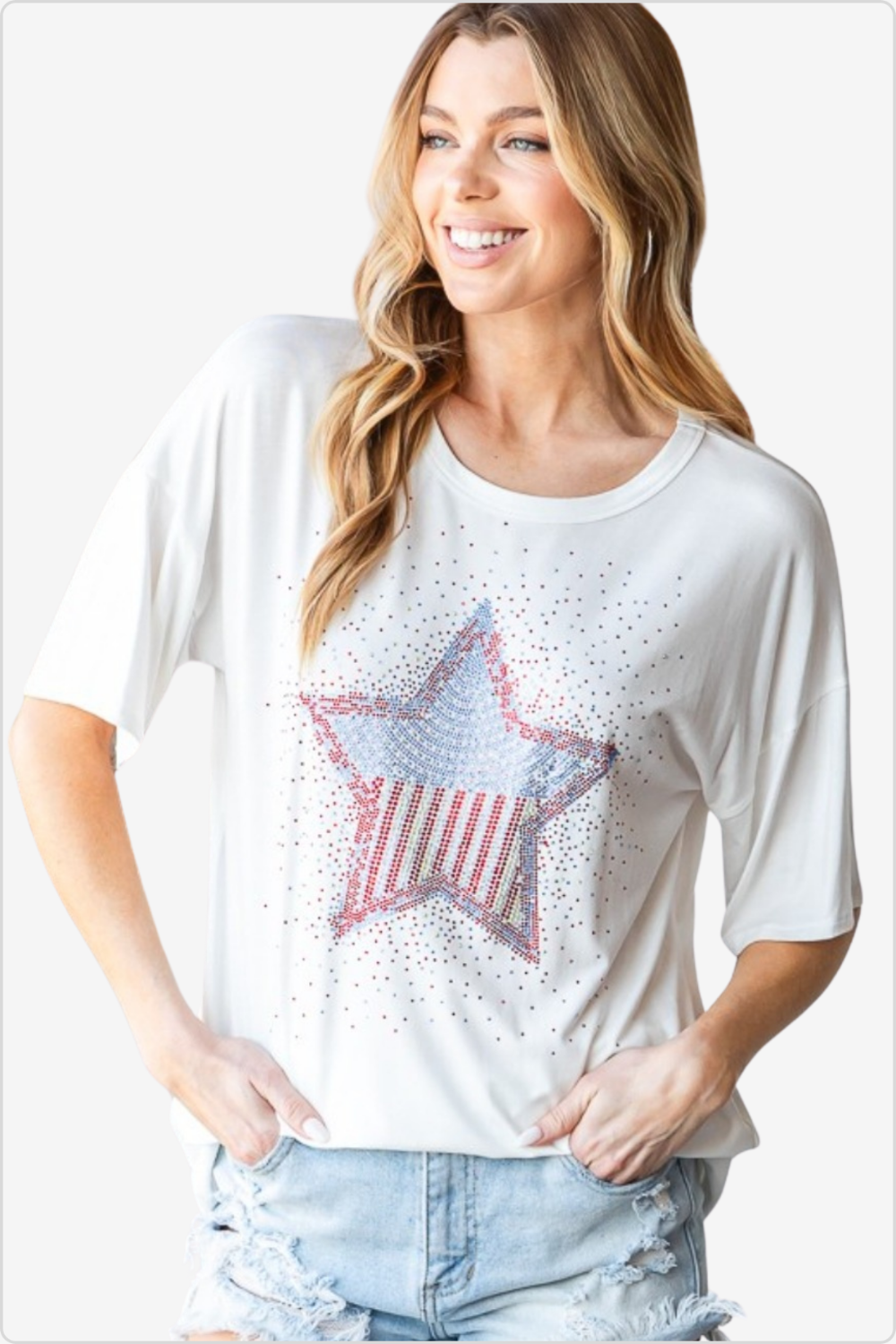 Smiling woman wearing a white graphic t-shirt with a rhinestone-studded American star, paired with distressed denim.