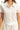Close-up of the textured fabric and button detail on the top, emphasizing the chic design.