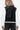 Back view of women’s varsity-style bomber jacket in black PU leather with white contrast sleeves.
