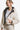 Woman wearing a reversible sherpa jacket, cream side out, with a black lining.