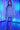 Woman in a light purple outfit with neon lights in the background