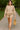 Smiling woman walking in ash mocha fleece sweatshirt and shorts set with sandals, park path daytime.