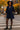Woman in navy mini dress walking down city street with autumn trees around