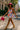 Model in color block top styled as mini dress with hot pink hat and yellow heels