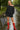Woman in black outfit with red boots holding a checkered umbrella on a rainy day.