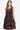 Woman in black sundress with vibrant red rose print, epitome of summer elegance.