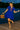 Dancing on dock in bohemian mini dress with embroidery, barefoot with woven bag, lakeside twilight, string lights
