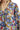 Close-up of a garment with a colorful floral pattern on a mustard background