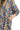 Close-up view of brown mix cotton fabric with floral boho print and ruffle detail.