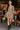Woman in paisley boho mini dress with combat boots and basket bag at outdoor flower market