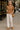 Woman standing in Cable Knit Sweater with loafers and crossbody bag, by café, soft daylight