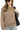 Woman wearing a brown textured sweater and sunglasses, holding a black bag on a white background