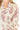 closeup-blouse-paisley-ruffle-sleeve → Close-up of ruffle V-neck and pink paisley print on cream fabric.