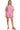 Model view of pink romper with green trim styled for casual wear