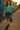 Walking by graffiti wall in cotton gauze shirt with asymmetrical skirt and boots, sunset light