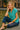 Sitting by fountain in cotton gauze shirt with striped pants and flats, city lights evening glow