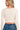 Back view of a ribbed crop pullover with a wrap style front and V neckline in cream color