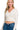 Model wearing a cream ribbed crop pullover with wrap front V-neckline and long sleeves