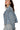 Side view of dusty blue denim jacket showing cropped hem and relaxed oversized fit