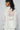 Back view of white crochet lace shirt with fringe hem and patchwork look