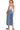 Back view of medium wash denim wide leg overalls with adjustable straps and wide hem.